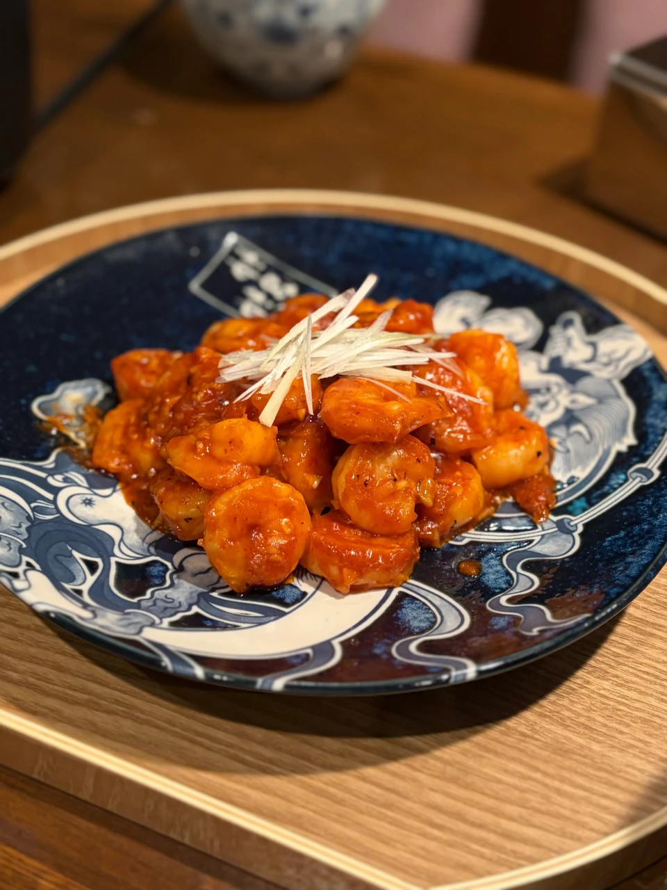 白髪ねぎを添えた赤いソースの料理